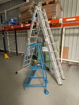 une photo d'une échelle dans un entrepôt, avec des cartons posés dessus