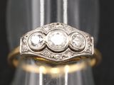 gros plan d'une bague en or ornée de trois diamants