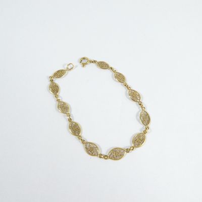 a close up of a gold bracelet on a white surface