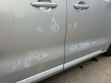 a silver car with bullet holes on the side of it