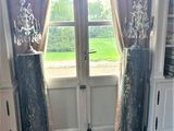 two tall vases sitting on the floor in front of a window
