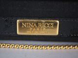 a close up of a black purse with a gold plate on it