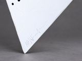 a white triangle shaped object on a gray surface