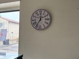 a clock that is on the wall above a glass table