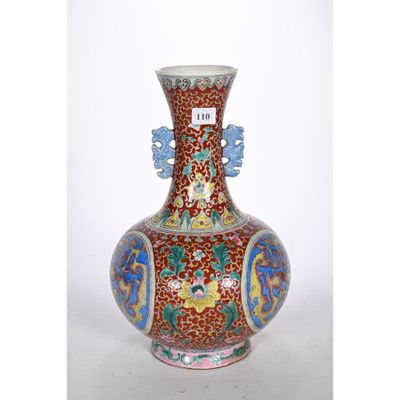 un vase rouge orné de motifs bleus et jaunes
