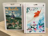 two boxes with paintings on them sitting on a table