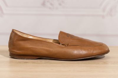 a close up of a pair of brown shoes on a wooden table