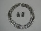 une photo d'un ensemble composé d'un collier et de boucles d'oreilles posé sur une table