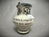 a white vase with writing on it sitting on a table
