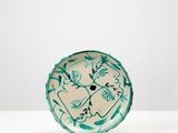 assiette en céramique turquoise et blanche ornée d'un motif floral