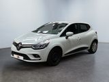 Une voiture blanche est garée dans une pièce au sol noir.