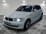 une photo d'une voiture bmw blanche dans une salle d'exposition