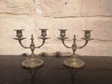 trois bougies posées sur une table devant un mur de briques