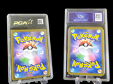 two packs of pokemon cards are in plastic holders on a black background