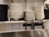 de nombreuses assiettes et casseroles empilées sur une étagère dans une cuisine