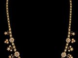 un collier en or orné de perles et de diamants sur fond noir