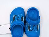 pair of children ' s blue crocs on white background with tag