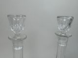 two clear glass candlesticks sitting on a table
