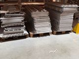 many stacks of steel plates stacked on pallets in a warehouse