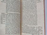 someone is holding a book open on a white surface