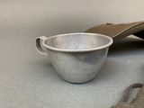 a metal bowl and a wooden spoon on a table