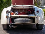 a white car with its trunk open and a tire in the back