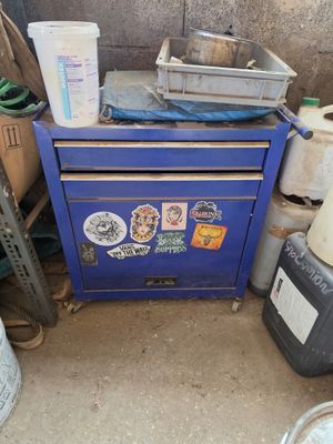 une photo d'une armoire bleue sur laquelle s'entassent toutes sortes d'objets