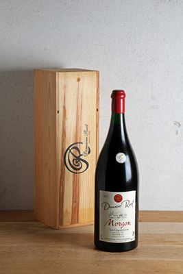 a bottle of wine sitting next to a wooden box on a table