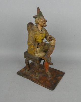 figurine représentant un homme assis sur un banc avec un chien