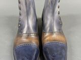 pair of blue and brown leather boots on a gray surface