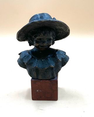 statue of a woman wearing a hat on a wooden block