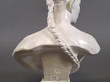 marble bust of a woman with braids on her hair