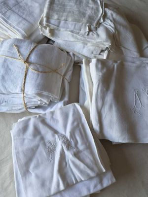 une pile de serviettes blanches sur un lit, à côté d'une paire de ciseaux