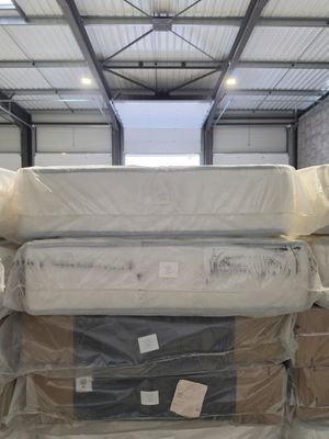 many mattresses stacked on top of each other in a warehouse