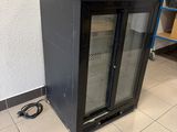 an image of a glass door refrigerator in a kitchen