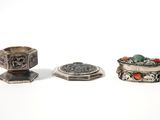 three different types of silver jewelry on a white surface