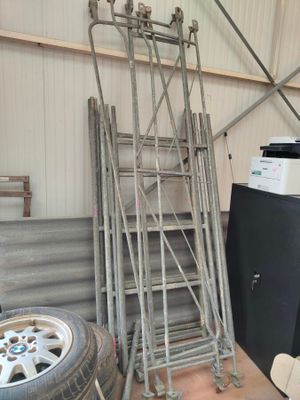 a lot of ladders that are stacked up in a garage