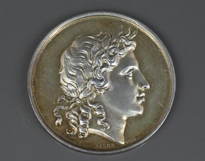 une image représentant une pièce d'argent sur laquelle figure la tête d'une femme