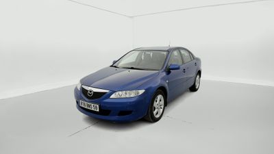 the blue car is parked in a white room with a white floor