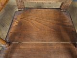 an old wooden chair sitting on top of a hard wood floor