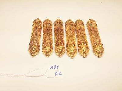 a group of five gold bracelets on a white surface