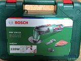 La boîte est verte, avec une poignée rouge et deux outils à l'intérieur.