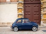 a small blue car parked in front of a building