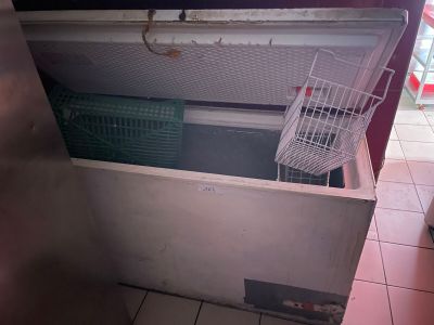 un congélateur ouvert dans une cuisine, avec un panier dans la porte