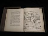 an open book with a picture of a forest in it