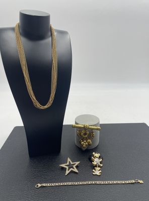 un mannequin noir portant un collier, un bracelet et un autre bracelet en or