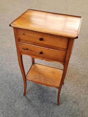 une petite table en bois avec deux tiroirs