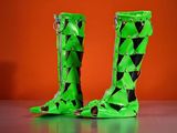 pair of green boots with black and white triangles on them