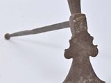 une vieille hache rouillée avec un manche en bois posée sur une surface blanche
