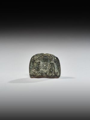 un vieil objet en pierre verte orné d'un motif